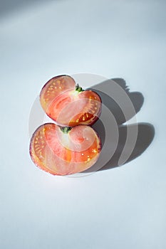 an heirloom tomato cut in half with one half on top of the other