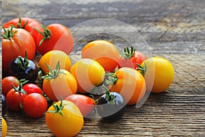 Heirloom variety tomatoes on rustic table. Colorful tomato - red,yellow , black, orange. Harvest vegetable cooking conception