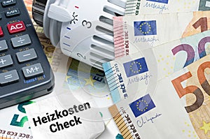 Heizkosten Check mit Heizthermostat und Taschenrechner auf Euro Banknoten photo