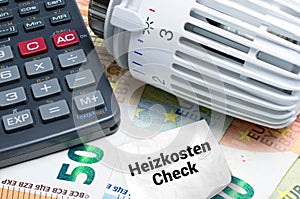 Heizkosten prÃÂ¼fen. Konzept mit Heizthermostat, Taschenrechner und Euro Banknoten photo