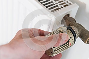 Hand on heater thermostat photo