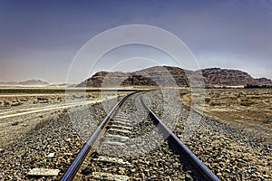 The Hejaz Railway under hazy blue skies in Wadi Rum desert