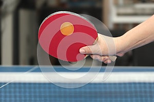 Held forehand counterhit orange table tennis ball near net on bl