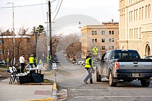 Helena, Montana / November 3, 2020: Election Day voting at polling station outside, woman poll worker in yellow vest wearing a