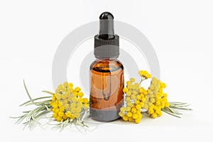 Helichrysum essential oil on amber bottle isolated on white background