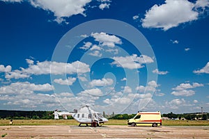 A helicopter and an ambulance are on the runway. Transport concept for medical personnel