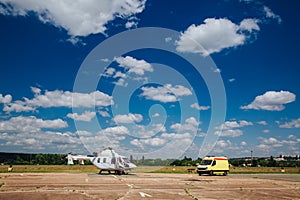 A helicopter and an ambulance are on the runway. Transport concept for medical personnel