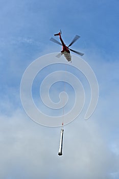 Helicopter as a flying crane transporting a pipe