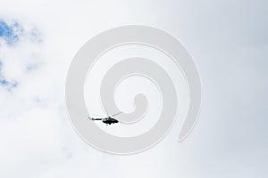 Helicopter on a background of blue sky with clouds