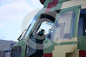 Helicopter cabin fragment close up. Camouflage aircraft fuselage and bulletproof glass