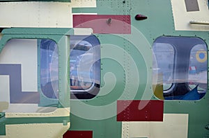 Helicopter cabin fragment close up. Camouflage aircraft fuselage and bulletproof glass