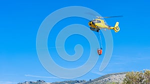 Helicopter collecting raft water to smother fire