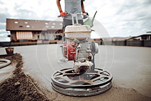 Helicopter concrete floor finishing on construction site. Construction worker finishing concrete screed with power trowel machine