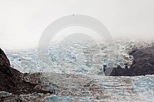 Helicopter dwarfed by nassive glacier ice flow