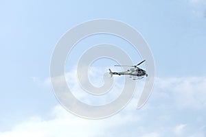 Helicopter equipped with camera for television in flight over blue sky