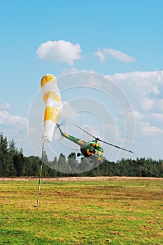 The helicopter is flying on airdrome