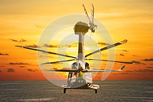 Helicopter flying into the sky with sunset or sunrise. The flight on the sky and travel to other place