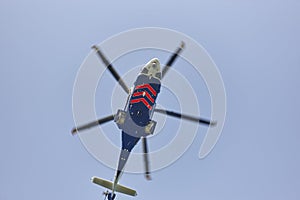 Helicopter flying under a blue sky from below. Transport