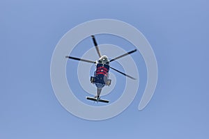 Helicopter flying under a blue sky from below. Transport