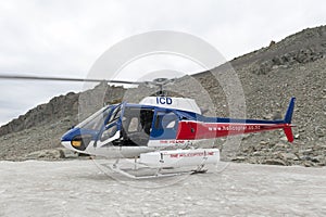 Helicopter from The Helicopter Line Company landing on snowcapped mountain peak around Aoraki Mount Cook and Mount Cook National