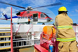 The helicopter on the helideck with the fireguard standing by