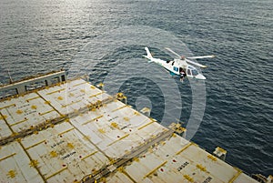 Helicopter hovering over the deck of a ship.