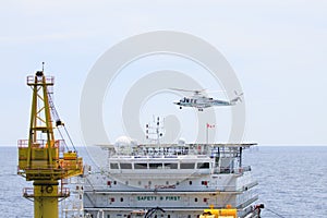 Helicopter landing on offshore oil rig, Passenger transfer to offshore oil and gas platform for work.