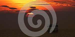 Helicopter landing on oil platform with beautiful sunset scene