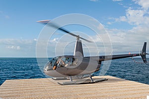 Helicopter landing at the pontoon helipad near Reef World on the Great Barrier Reef, Whitsunday Islands