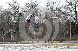 Helicopter landing in a small field with snow