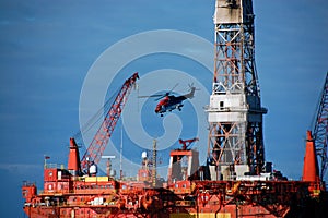 Helicopter leaving a Semi submergible rig. photo