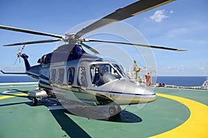 The helicopter park on oil rig platform to pick up worker with b