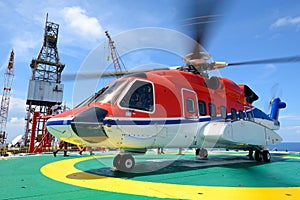 Helicopter pick up passenger on the offshore oil rig platform