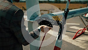 The helicopter pilot checks the performance of propellers before the flight