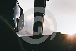 Helicopter pilot and helmet with sunset ahead in the cabin