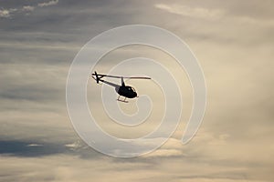 Helicopter silhouette against clouds