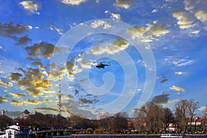 The helicopter takes off against the background of clouds and blue sky