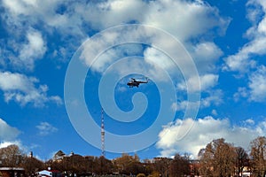 The helicopter takes off against the background of clouds and blue sky