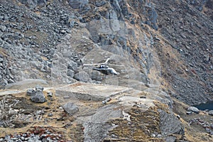 Helicopter taking off between the mountains of Nepal`s Langtang National Park