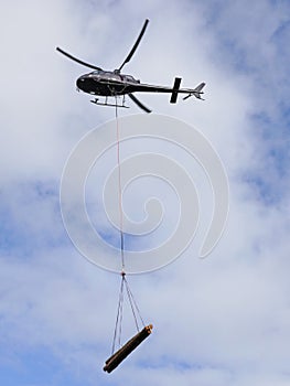 Helicopter transporting logs