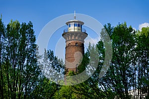 helios lighthouse behind trees