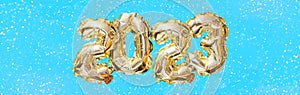 Helium golden balloon number of year 2023. Glowing festive garland with bokeh. Happy New Year banner