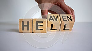 Hell or heaven. Hand turns a cube and changes the word `hell` to `heaven`. Concept. Beautiful white background, copy space
