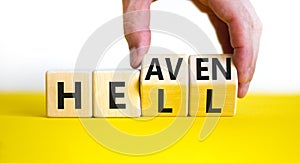 Hell or heaven symbol. Businessman turns wooden cubes and changes the word `hell` to `heaven`. Beautiful white background, cop