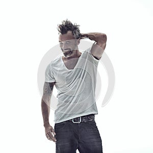 Hell never grow up. A mature bearded man with tattoos standing against a white background.