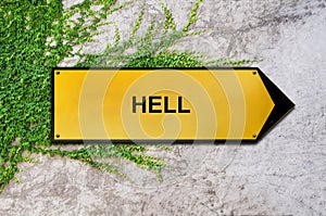 Hell on yellow sign hanging on ivy wall