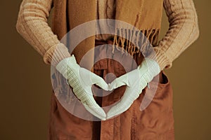 Stylish woman showing heart hands isolated on beige background photo