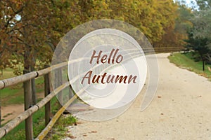 Hello Autumn greeting card with deserted gravel road in background