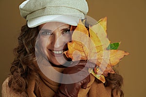 Happy trendy housewife in sweater isolated on brown background