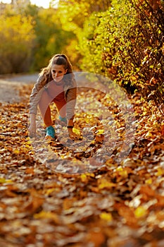 Hello autumn. woman in fitness clothes in the park stretching